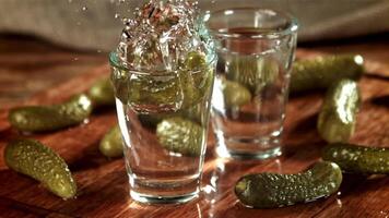 un en escabeche Pepino caídas dentro un vaso de vodka. filmado en un alta velocidad cámara a 1000 fps. alto calidad full HD imágenes video