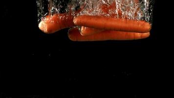 Carrot falls under water. Filmed is slow motion 1000 fps. High quality FullHD footage video