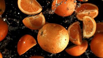 naranja rebanadas mosca arriba con agua gotas. filmado es lento movimiento 1000 fps. alto calidad full HD imágenes video