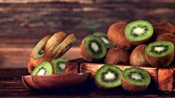 Super slow motion kiwi pieces fall into a wooden plate. On a wooden background. Filmed on a high-speed camera at 1000 fps. High quality FullHD footage video