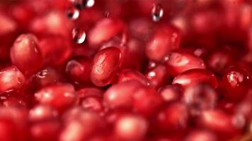 Super slow motion on the pomegranate grains fall drops of water. Macro background. Filmed on a high-speed camera at 1000 fps. High quality FullHD footage video