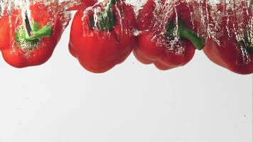 Super slow motion red pepper falls into the water with air bubbles on a white background. Filmed on a high-speed camera at 1000 fps.High quality FullHD footage video