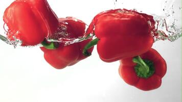 Super slow motion sweet pepper floats in the water with splashes. Filmed on a high-speed camera at 1000 fps.On a white background. video