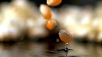 super langzaam beweging popcorn granen vallen in de olie. macro achtergrond.gefilmd Aan een hoge snelheid camera Bij 1000 fps. hoog kwaliteit full HD beeldmateriaal video