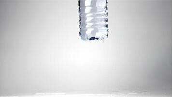 Super slow motion on the table falls a bottle of water. Filmed at 1000 fps.On a white background. video