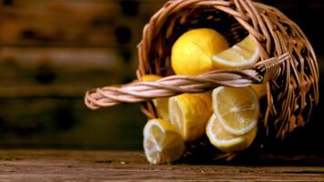 un súper lento movimiento cesta con limones caídas en el mesa. en un de madera antecedentes. filmado en un alta velocidad cámara a 1000 fps. alto calidad full HD imágenes video