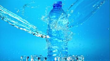 The super slow motion jet of water falls on the water bottle on the table. Filmed on a high-speed camera at 1000 fps.On a blue background. video