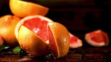 super langzaam beweging vers grapefruit valt Aan de tafel en splitst in twee. gefilmd Aan een hoge snelheid camera Bij 1000 fps.aan een houten achtergrond. video