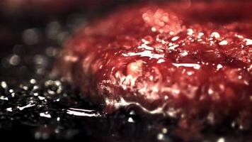 Super slow motion burger patty is fried with bubbles of oil in a frying pan. Filmed on a high-speed camera at 1000 fps.On a black background. video