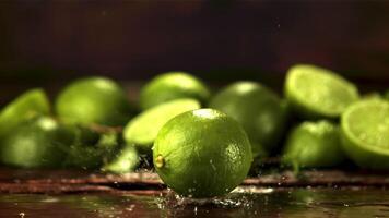 Super slow motion one lime falls on the table with splashes. Filmed on a high-speed camera at 1000 fps.On a wooden background. video