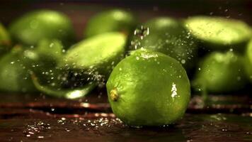 super lento movimento su succoso lime gocciola acqua con schizzi. contro un' buio sfondo. girato su un' alta velocità telecamera a 1000 fps. video