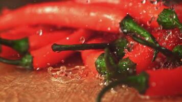 Super slow motion on the chilli pepper fall drops of water. On a gray background. Filmed on a high-speed camera at 1000 fps. High quality FullHD footage video