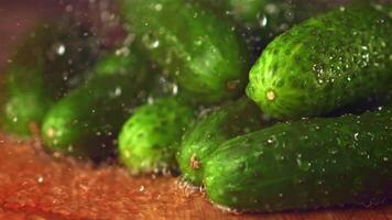 Super slow motion on fresh cucumbers drops water. On a wooden background.Filmed on a high-speed camera at 1000 fps. High quality FullHD footage video