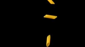 Super slow motion pasta penne dry falls on the table. On a black background. Filmed on a high-speed camera at 1000 fps. High quality FullHD footage video