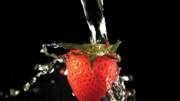 Super slow motion on the rotating strawberries drops water. On a black background. Filmed on a high-speed camera at 1000 fps.High quality FullHD footage video