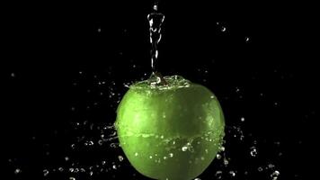 Super slow motion water droplets fall on the rotating apple. On a black background. Filmed on a high-speed camera at 1000 fps. video