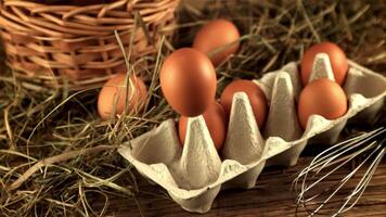 Super slow motion egg falls into a cardboard box on the table. On a wooden background.Filmed on a high-speed camera at 1000 fps. video