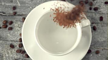 súper lento movimiento instante café caídas dentro un taza de agua. en un blanco antecedentes. filmado en un alta velocidad cámara a 1000 fps. video