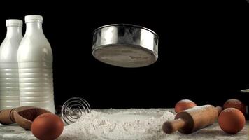 Super slow motion sieve falls into a pile of flour on the table. On a black background. Filmed on a high-speed camera at 1000 fps. video