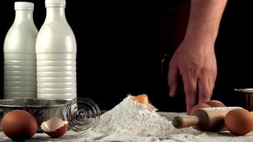 Super slow motion raw egg falls in a pile of flour on the table. On a black background. Filmed on a high-speed camera at 1000 fps. video