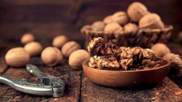 Super slow motion plate with walnuts falls on the table. On a wooden background.Filmed on a high-speed camera at 1000 fps. video