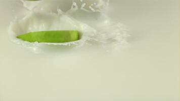 Super slow motion pieces of fresh apple fall into the milk with splashes. Filmed on a high-speed camera at 1000 fps On a white background. video