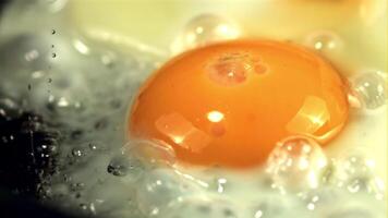 Super slow motion egg is fried with air bubbles. Macro background. Filmed on a high-speed camera at 1000 fps. video