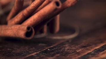 A super slow motion pile of cinnamon sticks falls on a wooden table. On a wooden background.Filmed on a high-speed camera at 1000 fps. video