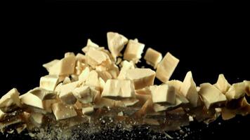 Pieces of white chocolate fly up and fall down. Filmed on a high-speed camera at 1000 fps. High quality FullHD footage video