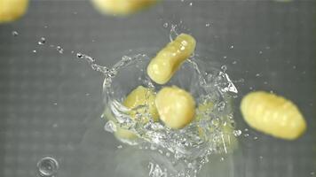 Italienisch Gnocchi fallen in das Wasser mit Spritzer. gefilmt auf ein schnelle Geschwindigkeit Kamera beim 1000 fps. hoch Qualität fullhd Aufnahmen video