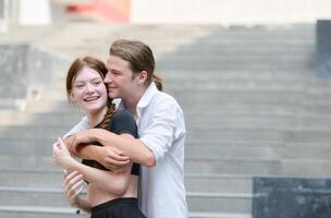 A couple is enjoying a summer vacation in the community area, happily showing their love to each other. photo