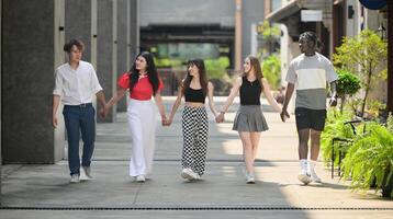 Group of young multiethnic friend having fun and laughing outdoors on beautiful summer day photo