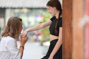 A couple is enjoying a summer vacation in the community streets, happily showing their love to each other. photo