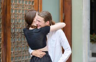 A couple is enjoying a summer vacation in the community streets, happily showing their love to each other. photo