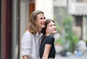 un Pareja es disfrutando un verano vacaciones en el comunidad calles, felizmente demostración su amor a cada otro. foto