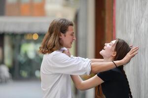 un Pareja es disfrutando un verano vacaciones en el comunidad calles, felizmente demostración su amor a cada otro. foto