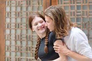 A couple is enjoying a summer vacation in the community streets, happily showing their love to each other. photo