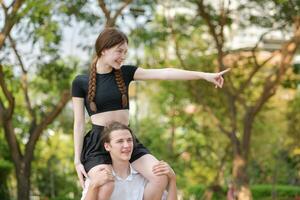 un Pareja es disfrutando un verano vacaciones en el parque, felizmente demostración su amor a cada otro. foto