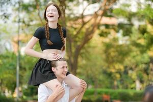 un Pareja es disfrutando un verano vacaciones en el parque, felizmente demostración su amor a cada otro. foto