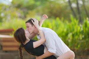 un Pareja es disfrutando un verano vacaciones en el parque, felizmente demostración su amor a cada otro. foto