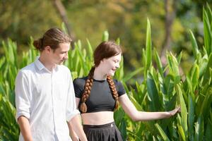 A couple is enjoying a summer vacation in the park, happily showing their love to each other. photo