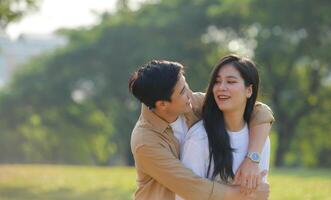 LGBT couple is enjoying a summer vacation in the park, happily showing their love to each other. photo