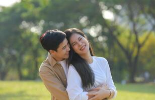 LGBT couple is enjoying a summer vacation in the park, happily showing their love to each other. photo