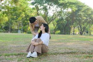 lgbt Pareja es disfrutando un verano vacaciones en el parque, felizmente demostración su amor a cada otro. foto