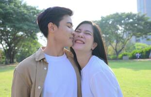 LGBT couple is enjoying a summer vacation in the park, happily showing their love to each other. photo