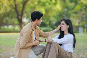 LGBT couple is enjoying a summer vacation in the park, happily showing their love to each other. photo