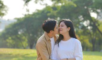 LGBT couple is enjoying a summer vacation in the park, happily showing their love to each other. photo