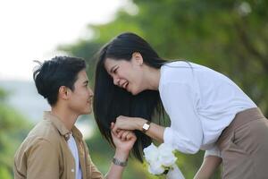 LGBT couple is enjoying a summer vacation in the park, happily showing their love to each other. photo