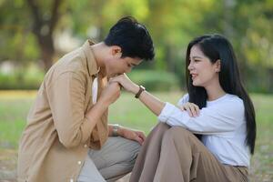 LGBT couple is enjoying a summer vacation in the park, happily showing their love to each other. photo