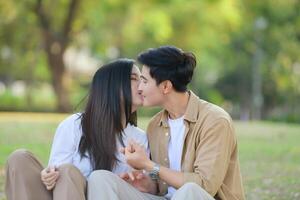 LGBT couple is enjoying a summer vacation in the park, happily showing their love to each other. photo